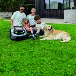 photo d'une famille sur une pelouse avec 2 adultes, 2 enfants, un chien et le robot RMR